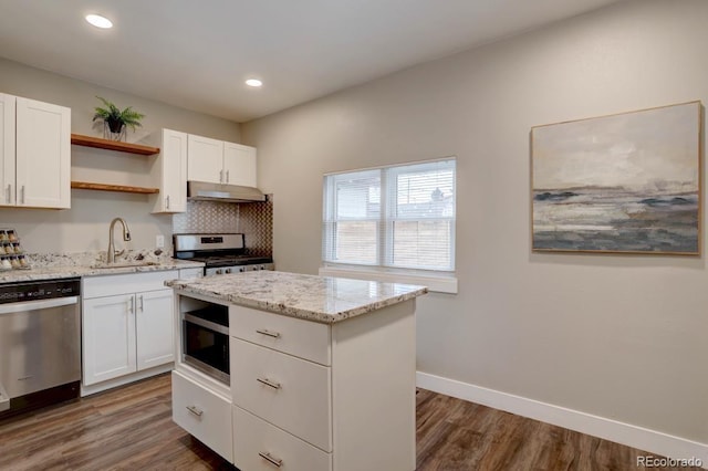 kitchen featuring under cabinet range hood, stainless steel appliances, a sink, baseboards, and open shelves