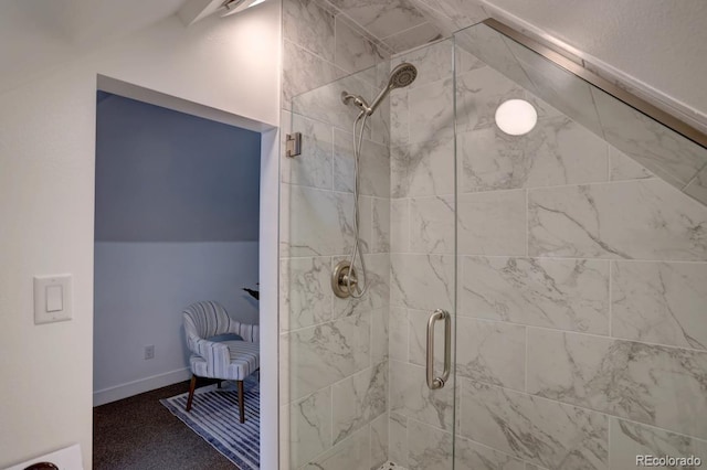 bathroom with lofted ceiling, a stall shower, and baseboards