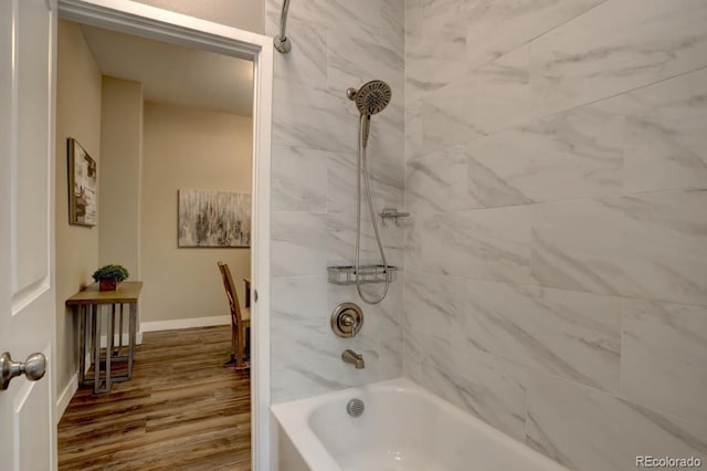 bathroom with shower / washtub combination, baseboards, and wood finished floors