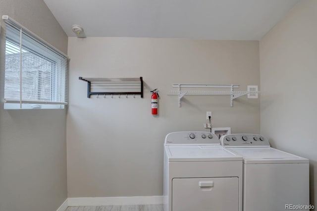 clothes washing area with laundry area, washer and clothes dryer, and baseboards