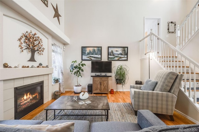 living room featuring a tiled fireplace and hardwood / wood-style flooring