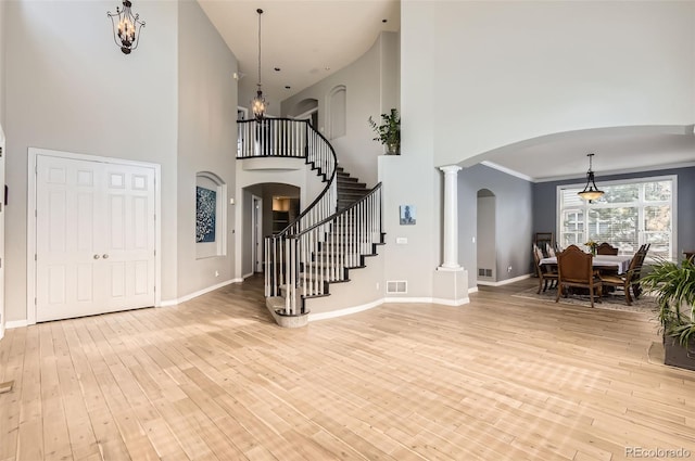 7866 Witney Pl, Lone Tree, CO 80124 - entrance foyer featuring a towering ceiling, light wood-style flooring, arched walkways, stairs, and a chandelier
