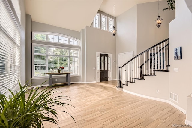 7866 Witney Pl, Lone Tree, CO 80124 - entryway featuring wood-type flooring, a towering ceiling, a chandelier, and stairs