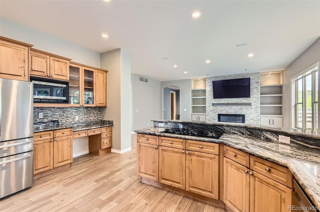 7866 Witney Pl, Lone Tree, CO 80124 - kitchen featuring appliances with stainless steel finishes, decorative backsplash, light wood-style floors, arched walkways, and dark stone countertops