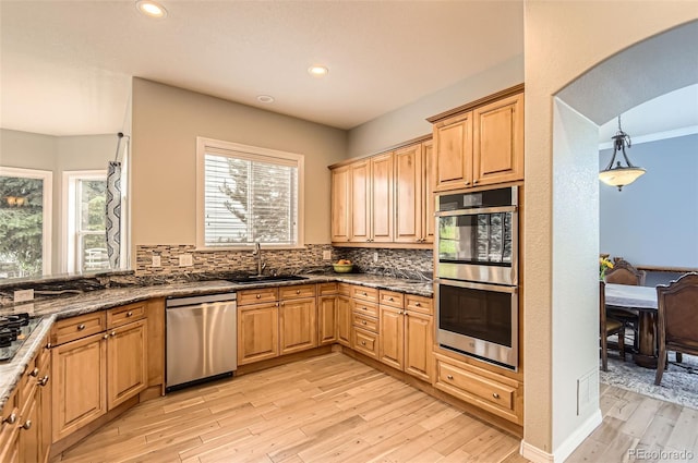 7866 Witney Pl, Lone Tree, CO 80124 - kitchen featuring appliances with stainless steel finishes, light wood-style floors, decorative backsplash, recessed lighting, and dark stone countertops