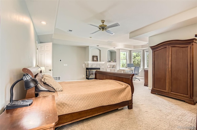 7866 Witney Pl, Lone Tree, CO 80124 - bedroom with a multi sided fireplace, light carpet, a tray ceiling, recessed lighting, and ceiling fan