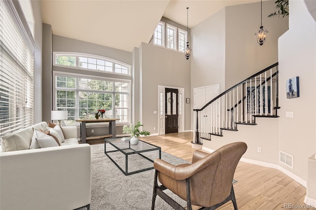 7866 Witney Pl, Lone Tree, CO 80124 - living area featuring light wood-style floors, a towering ceiling, stairs, and a chandelier