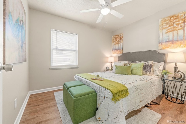 bedroom featuring ceiling fan, a textured ceiling, and wood-type flooring