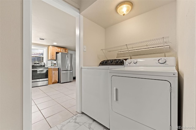 clothes washing area with washing machine and dryer