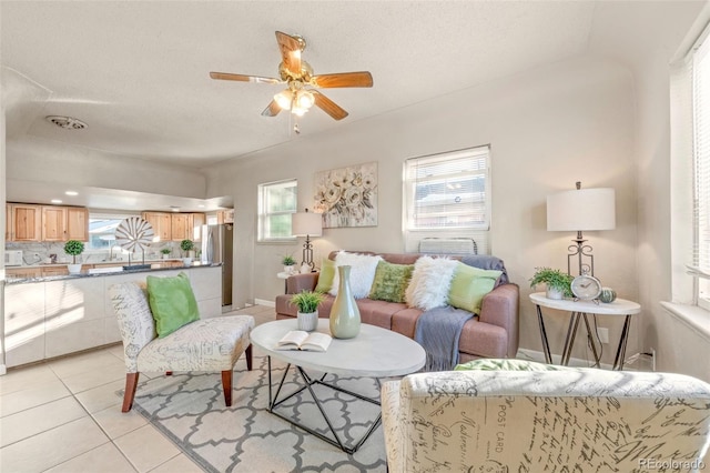 living room with light tile patterned floors, a textured ceiling, and ceiling fan