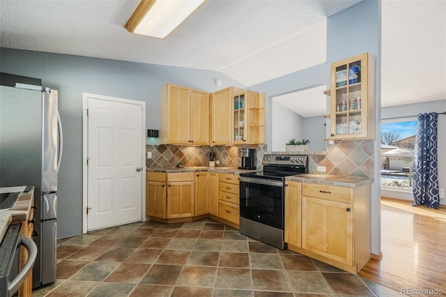 kitchen featuring decorative backsplash, a textured ceiling, stainless steel appliances, vaulted ceiling, and light brown cabinets