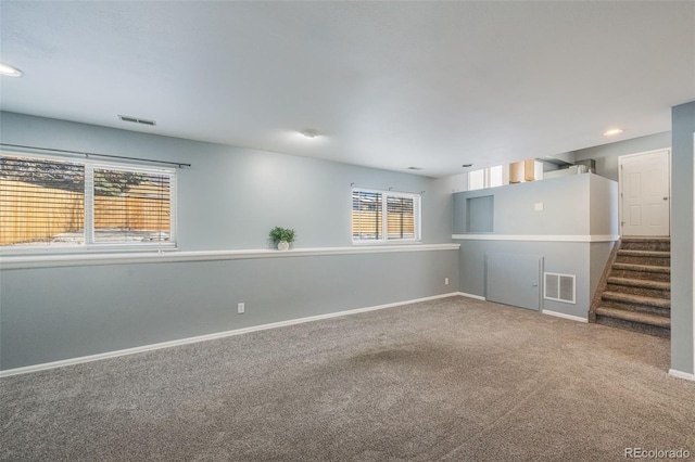 spare room featuring carpet flooring and a wealth of natural light