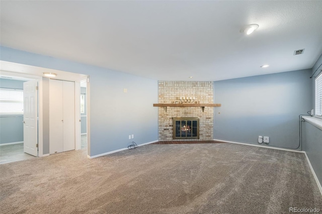 unfurnished living room featuring carpet and a brick fireplace