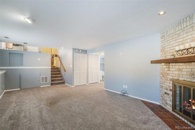 unfurnished living room with dark carpet and a brick fireplace