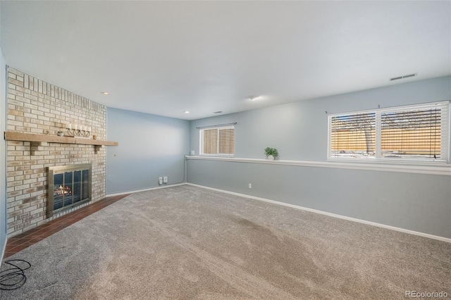 unfurnished living room featuring carpet flooring and a brick fireplace