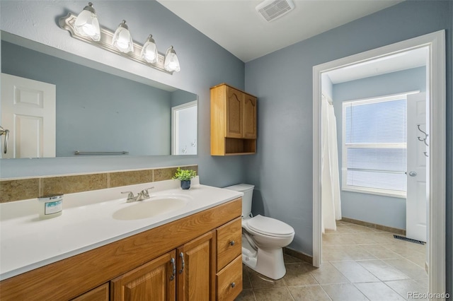 bathroom with tile patterned flooring, vanity, and toilet