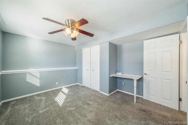 unfurnished bedroom featuring ceiling fan, a closet, and dark carpet