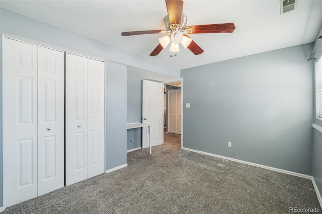 unfurnished bedroom featuring dark colored carpet, a closet, and ceiling fan