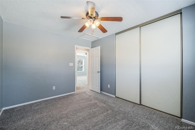 unfurnished bedroom featuring carpet flooring, a textured ceiling, a closet, and ceiling fan