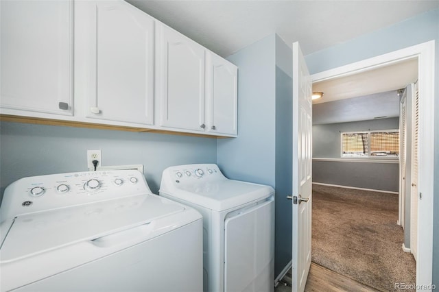 washroom with cabinets, washing machine and dryer, and carpet floors