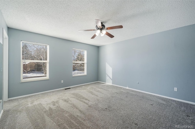 carpeted empty room featuring a textured ceiling and ceiling fan