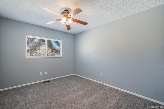 carpeted empty room featuring ceiling fan and a textured ceiling