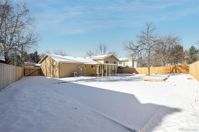 snow covered back of property with central air condition unit