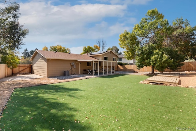 rear view of house featuring a patio, a deck, and a lawn