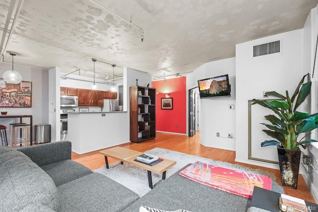 444 17th St Unit 603, Denver, CO 80202 - living room featuring visible vents, light wood-style flooring, and rail lighting