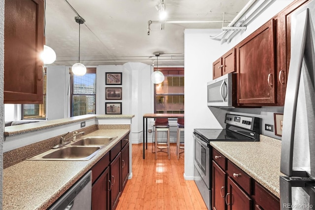 444 17th St Unit 603, Denver, CO 80202 - kitchen with light countertops, light wood finished floors, stainless steel appliances, a sink, and hanging light fixtures