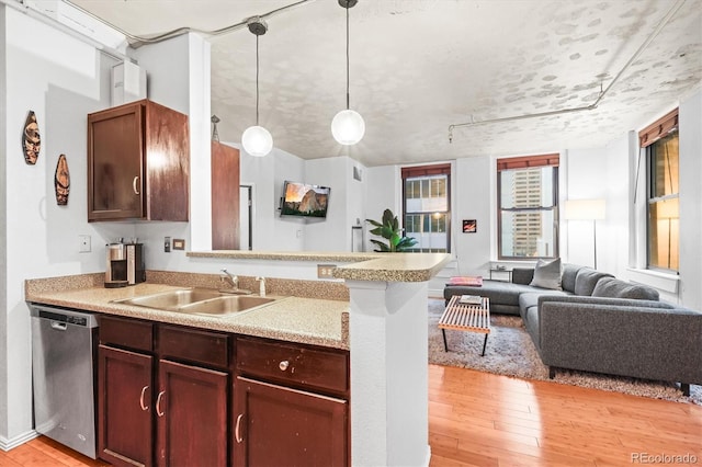 444 17th St Unit 603, Denver, CO 80202 - kitchen featuring light countertops, a sink, light wood finished floors, stainless steel dishwasher, and open floor plan