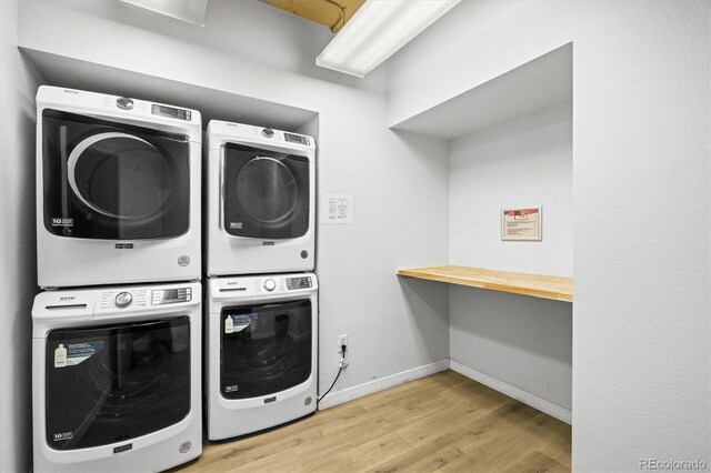 444 17th St Unit 603, Denver, CO 80202 - laundry room featuring baseboards, stacked washer / drying machine, and wood finished floors