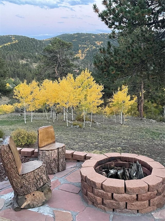 view of patio with an outdoor fire pit and a mountain view