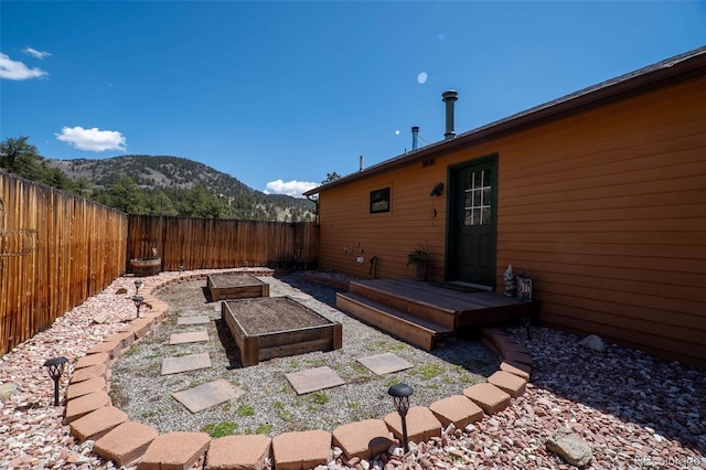 fenced backyard featuring a mountain view and a vegetable garden
