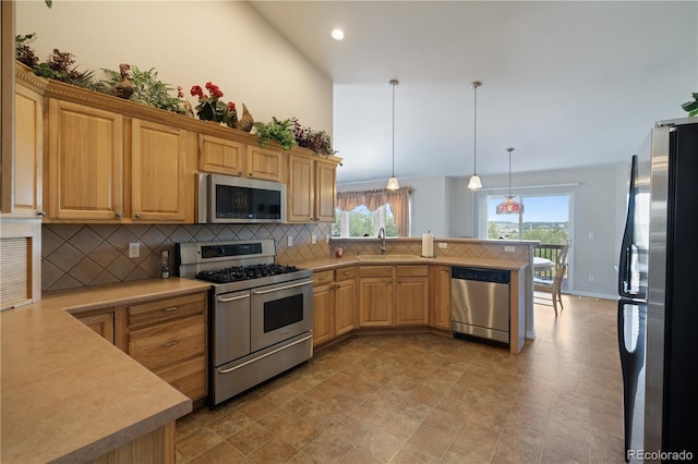 kitchen featuring tasteful backsplash, a peninsula, stainless steel appliances, and light countertops