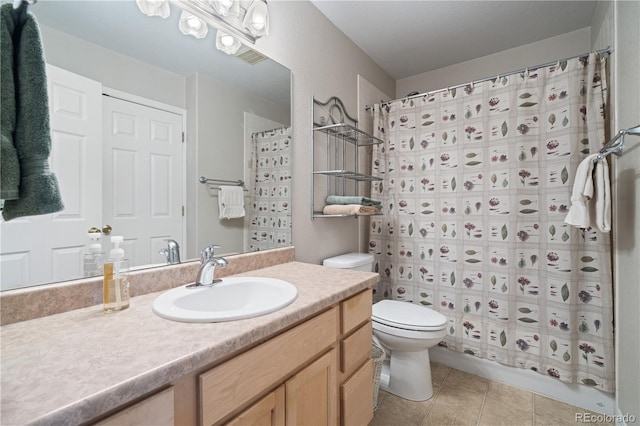 full bathroom with toilet, vanity, and tile patterned flooring