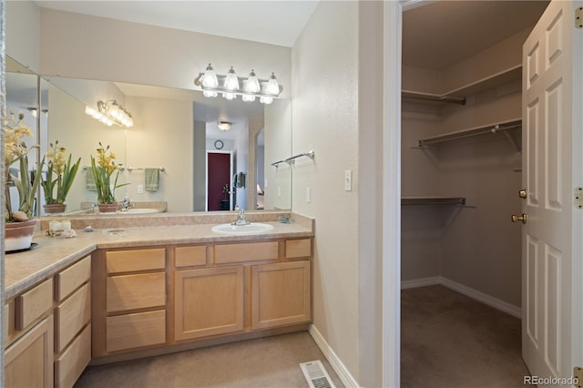 full bathroom with visible vents, baseboards, vanity, and a spacious closet