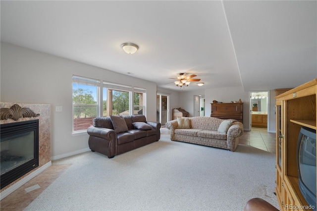 living area featuring baseboards, light colored carpet, light tile patterned flooring, and a fireplace