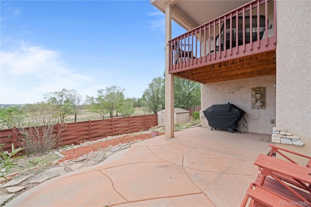 view of patio with a storage shed, a fenced backyard, an outdoor structure, and grilling area