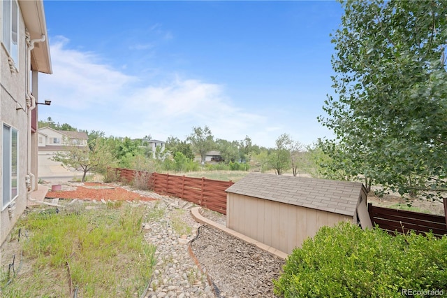 view of yard with an outbuilding, a shed, and a fenced backyard