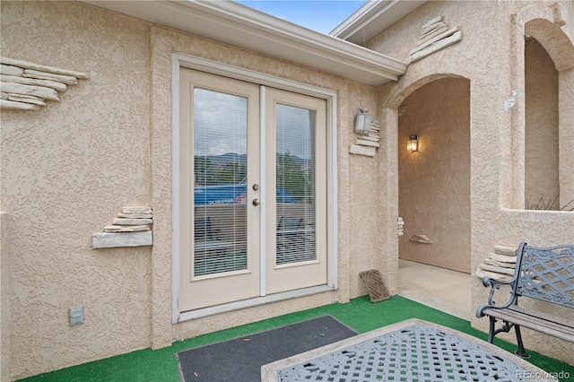 doorway to property with stucco siding, a patio, and french doors