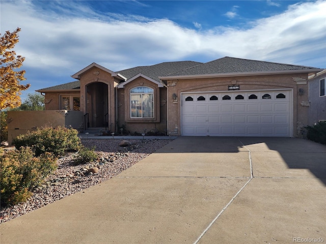 view of front of house with an attached garage, driveway, and stucco siding