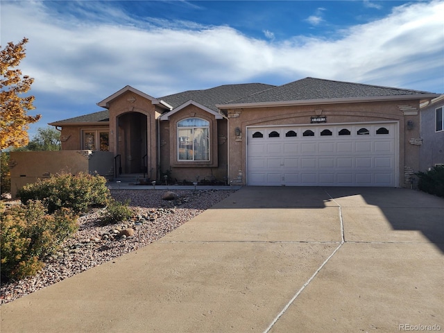 1443 W Costilla St, Colorado Springs, CO 80905 - ranch-style house with stucco siding, driveway, and a garage