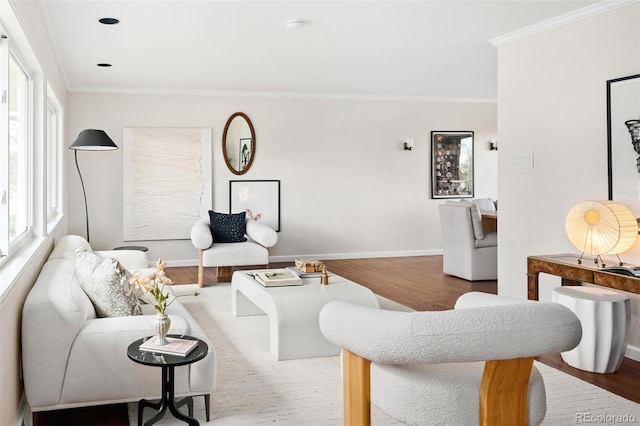 living area with baseboards, ornamental molding, and wood finished floors