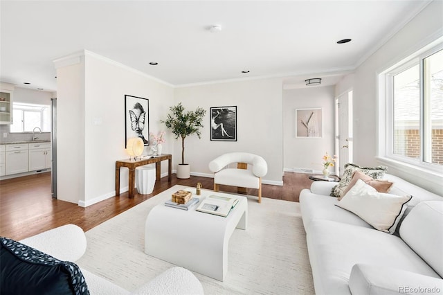 living area featuring ornamental molding, light wood finished floors, recessed lighting, and baseboards