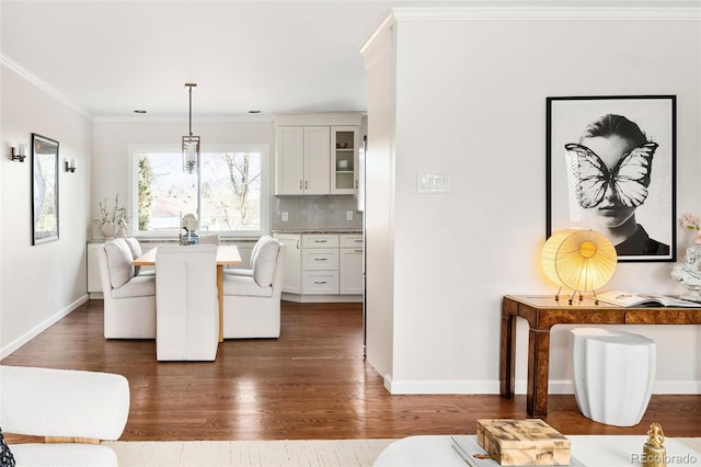 dining room with baseboards, dark wood finished floors, and crown molding