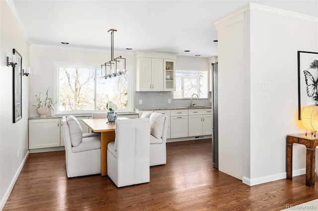 dining room featuring baseboards, dark wood-style flooring, and crown molding