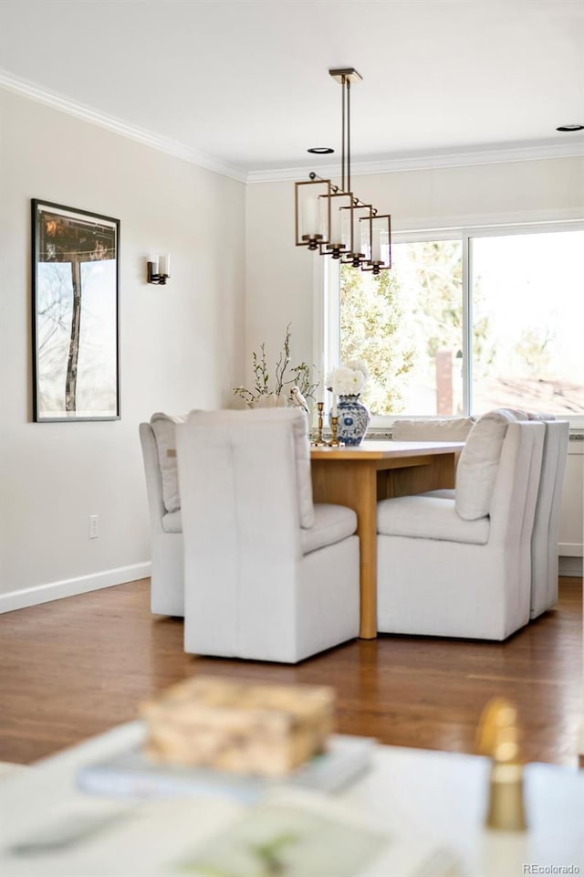 dining area with baseboards, ornamental molding, breakfast area, wood finished floors, and an inviting chandelier