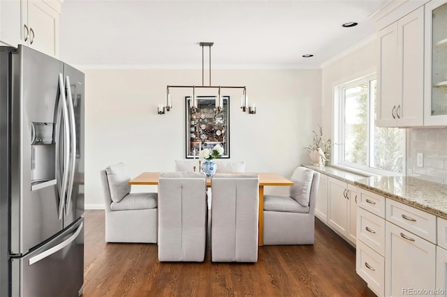 dining space featuring breakfast area, dark wood finished floors, and crown molding