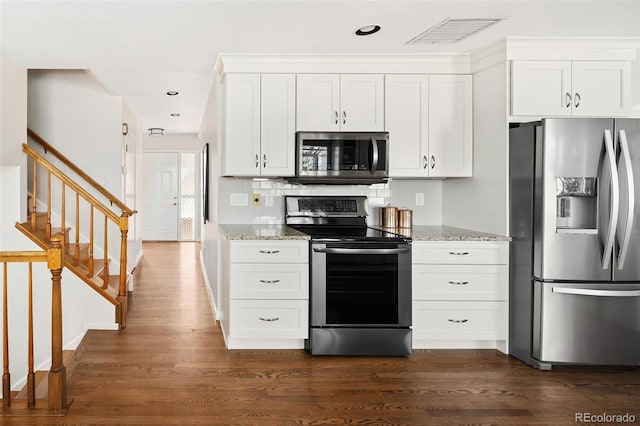 kitchen with appliances with stainless steel finishes, dark wood-style flooring, visible vents, and light stone countertops